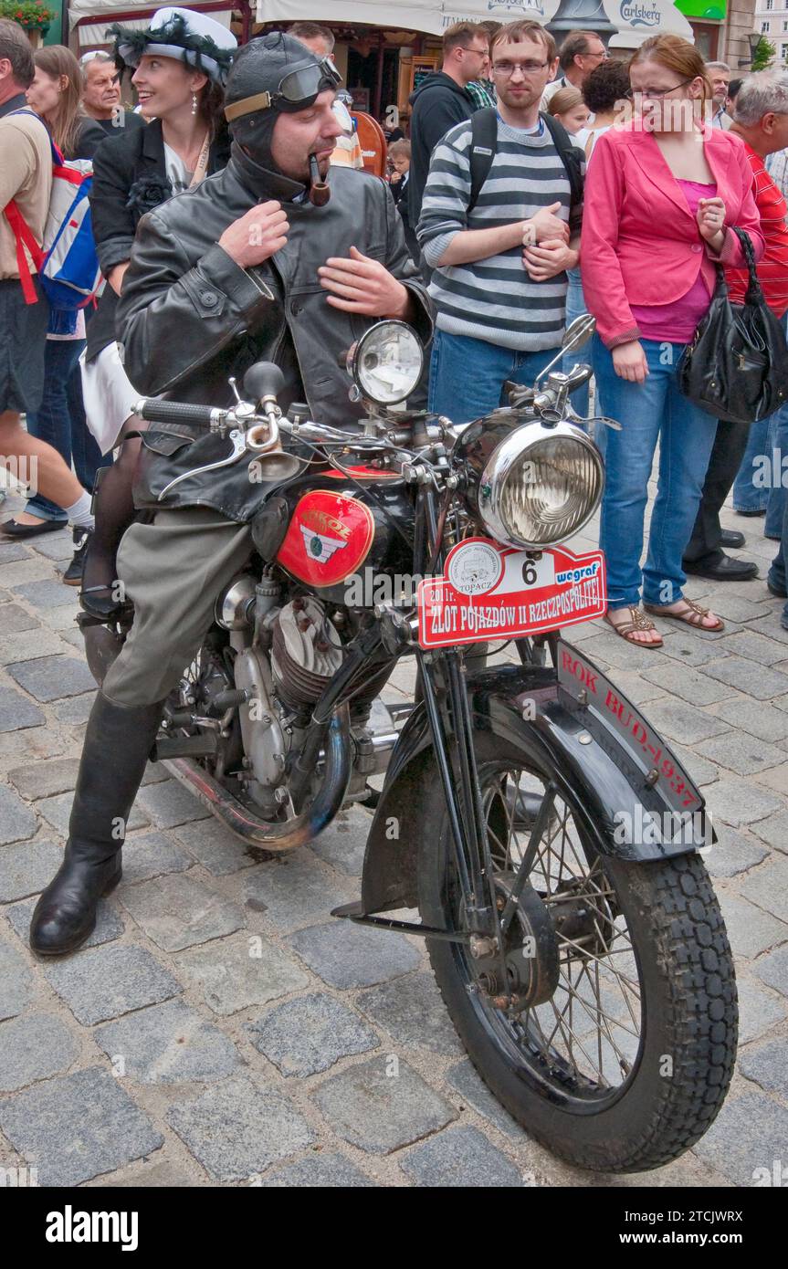 1930s Sokol 600, Polish motorcycle, costumed biker in soft helmet, smoking pipe, young woman, Vehicles of Interwar Poland Rally at Rynek (Market Square) in Wroclaw, Lower Silesia, Poland Stock Photo