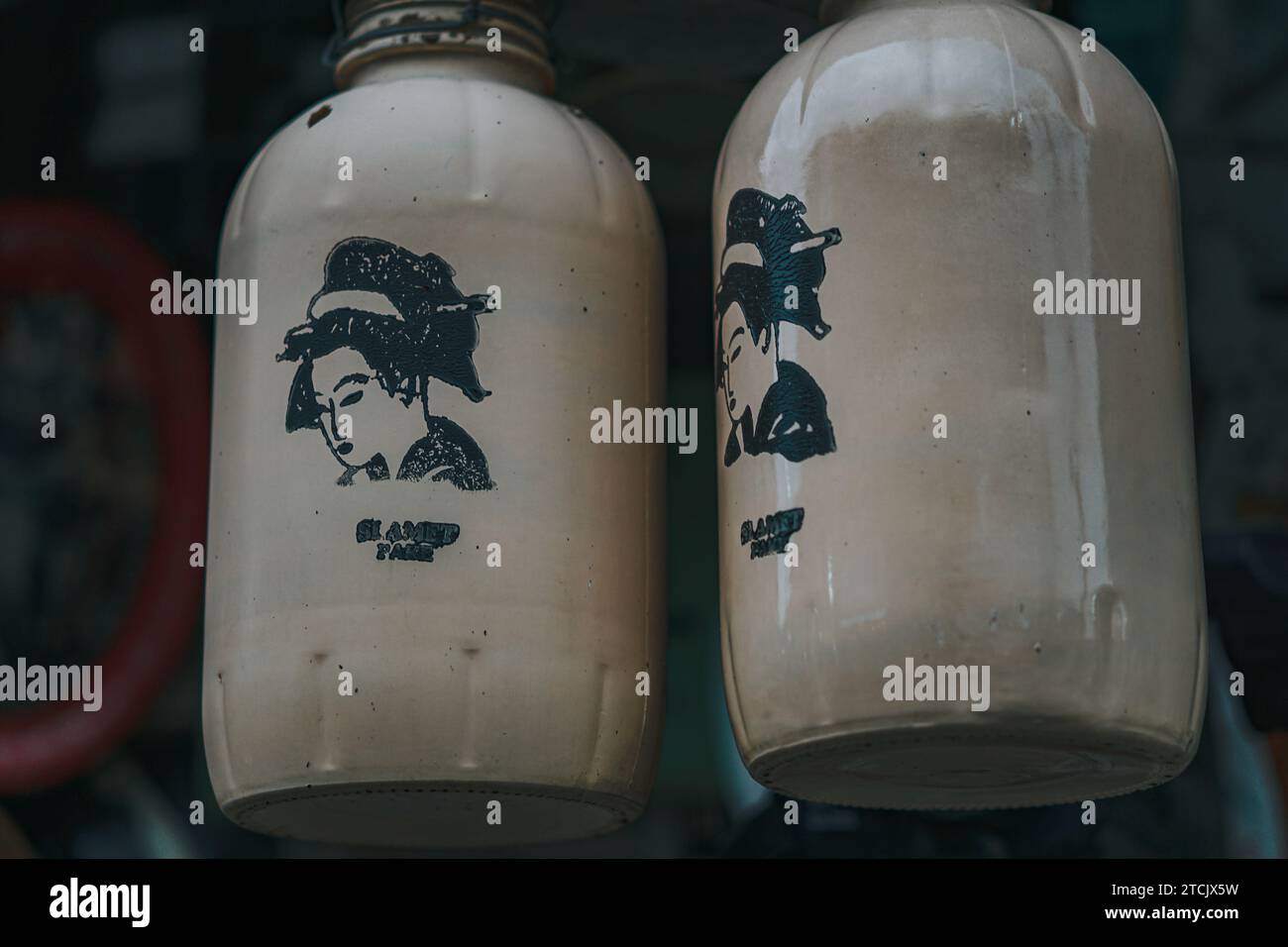 Two white historical sake bottles on display Stock Photo