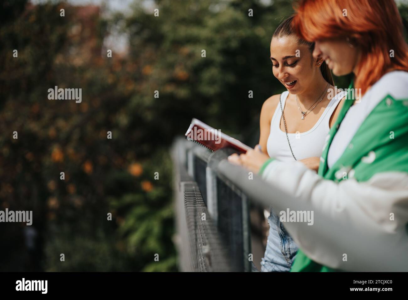 Stylish Girls Collaborating on Homework in Urban City Stock Photo - Alamy