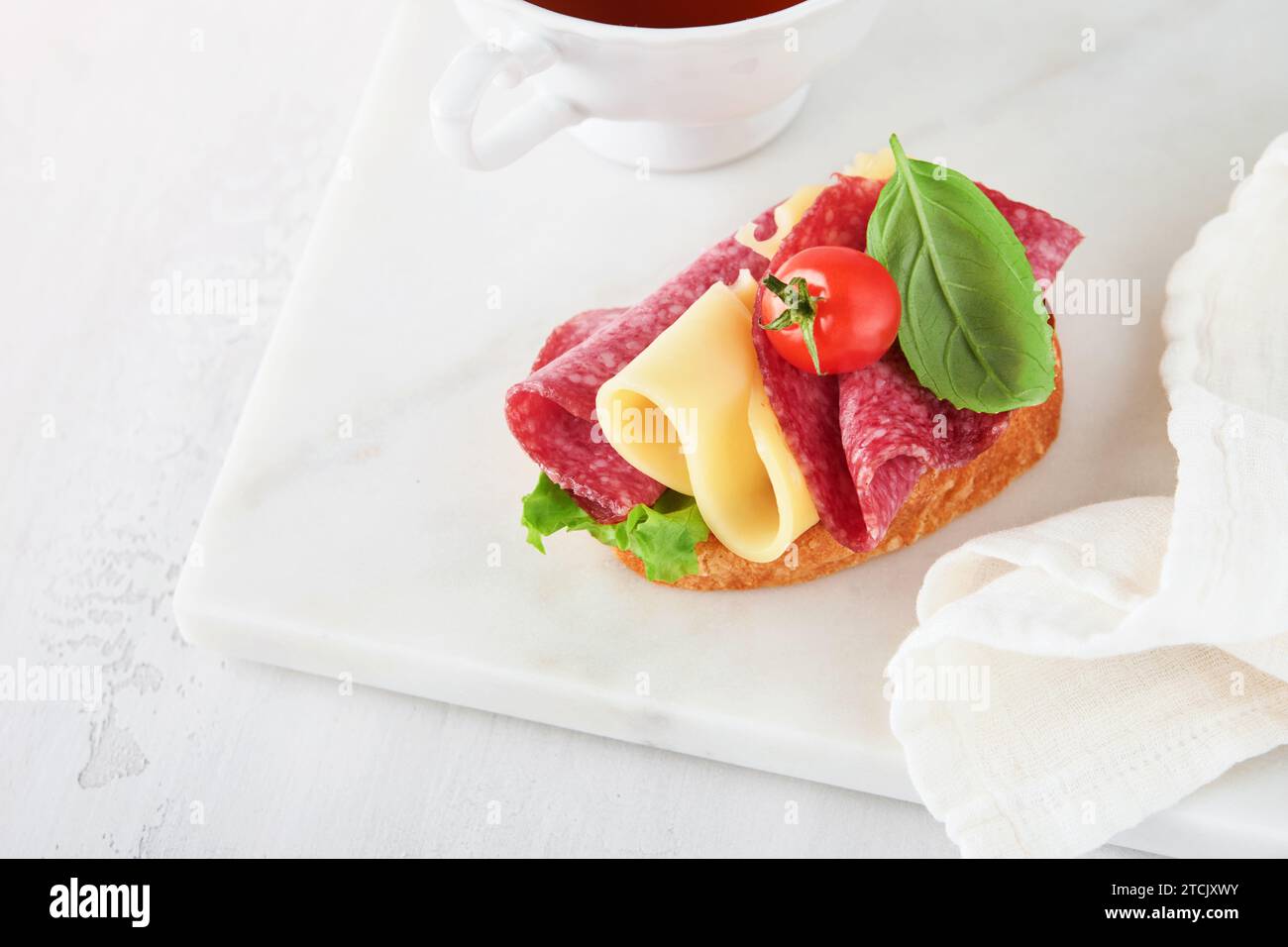 Salami sandwich. Delicious toasted sandwiches with slice salami, cheddar cheese lettuce and tomatoes cherry on white marble background. Restaurant men Stock Photo
