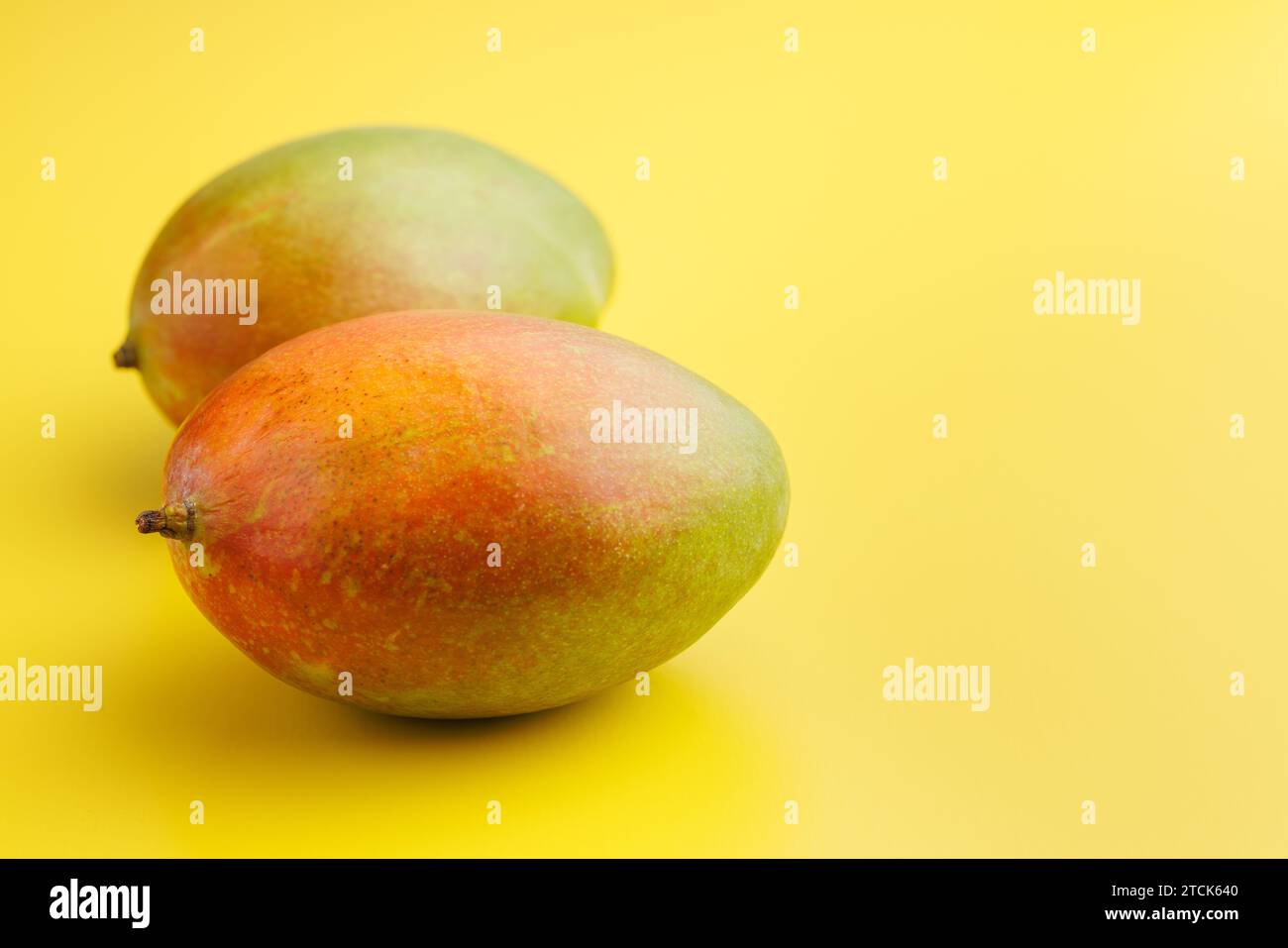Ripe mango fruit on the yellow background. Stock Photo