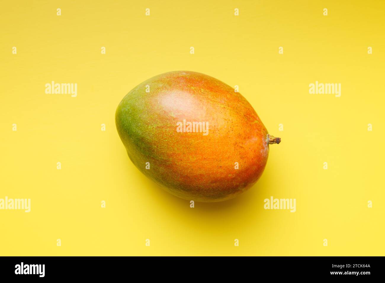 Ripe mango fruit on the yellow background. Top view. Stock Photo