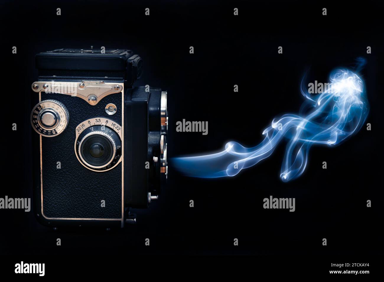 classic photo camera twin lens, emitting a blue smoke Stock Photo