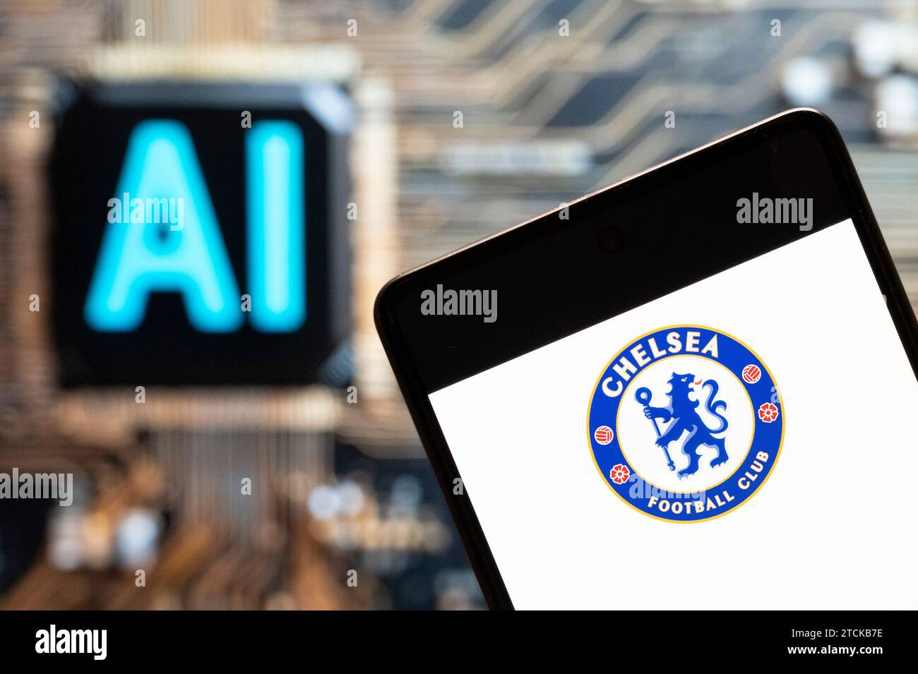In this photo illustration, the English professional Premier League football club Chelsea team logo seen displayed on a smartphone with an Artificial intelligence (AI) chip and symbol in the background. Stock Photo