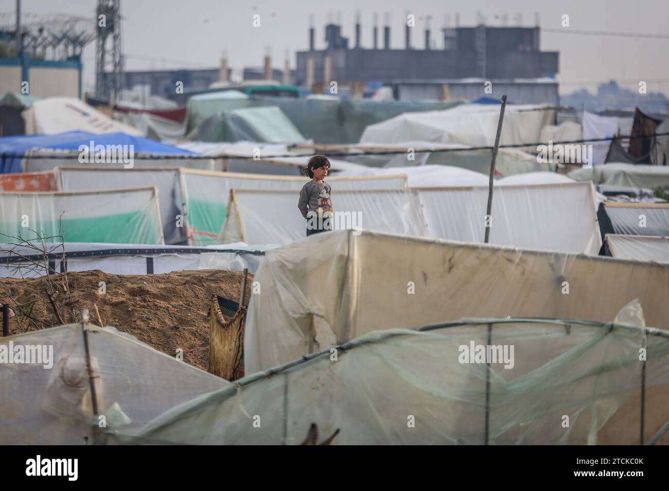 Rafah, Palestinian Territories. 13th Dec, 2023. A Palestinian child stands near his family's makeshift tent at camp for displaced people. Credit: Mohammed Talatene/dpa/Alamy Live News Stock Photo