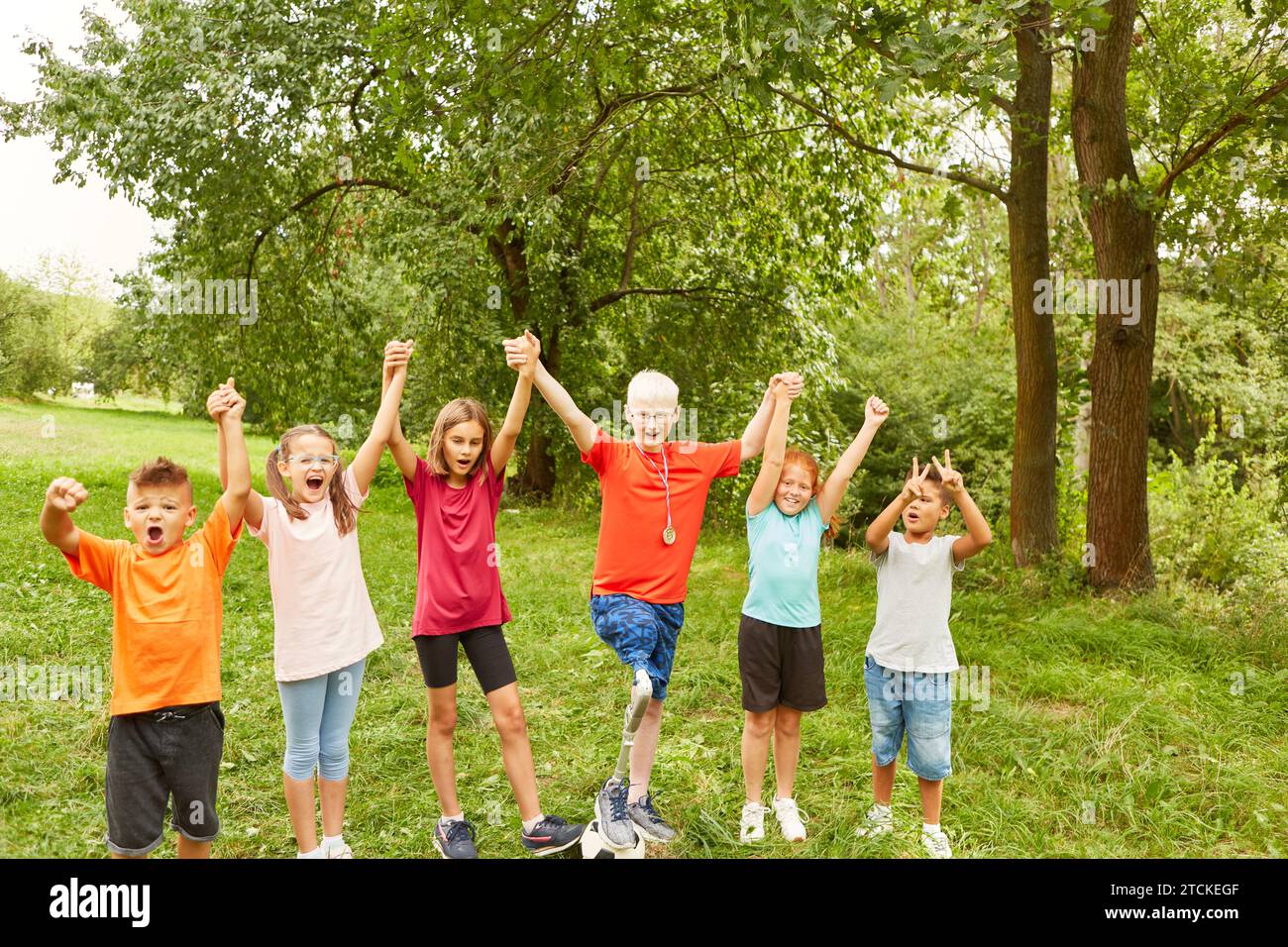 Cheerful male and female friends holding hands while celebrating at park Stock Photo