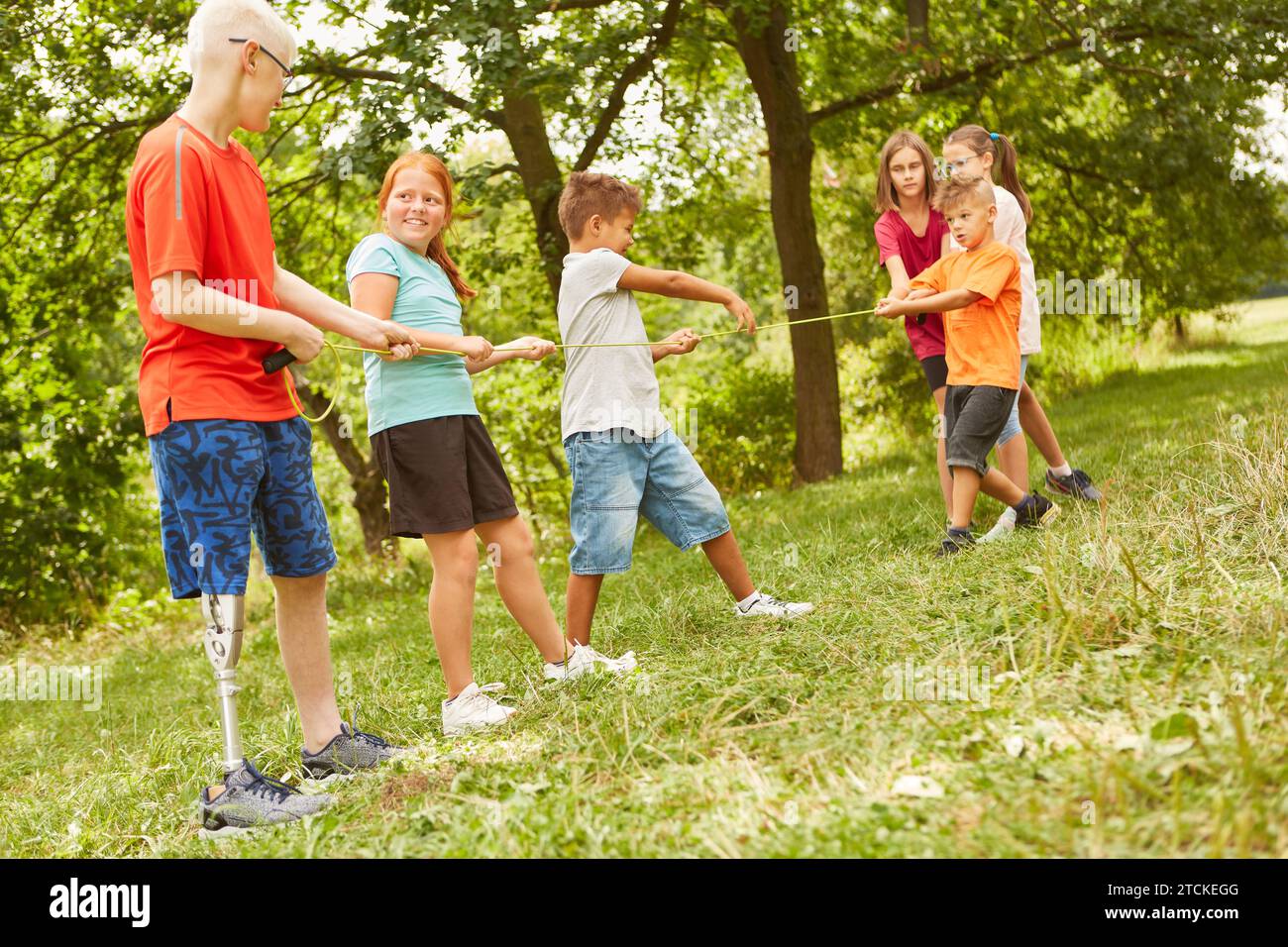Male and female friends playing games with rope at park Stock Photo