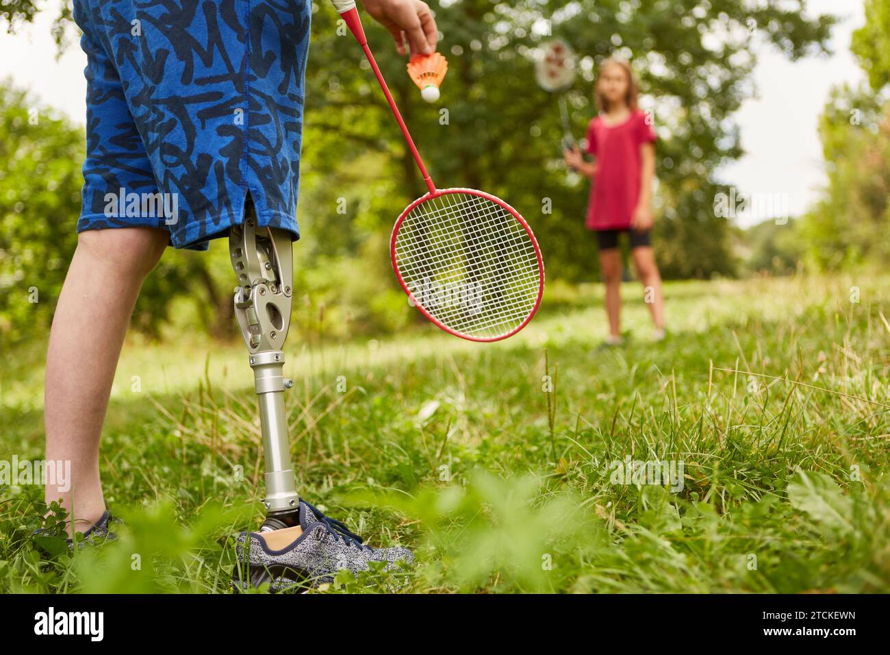 Low section of boy with amputated leg playing badminton at park Stock Photo