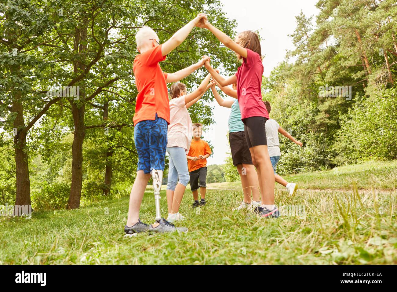 Group of male and female friends playing games while standing at park Stock Photo