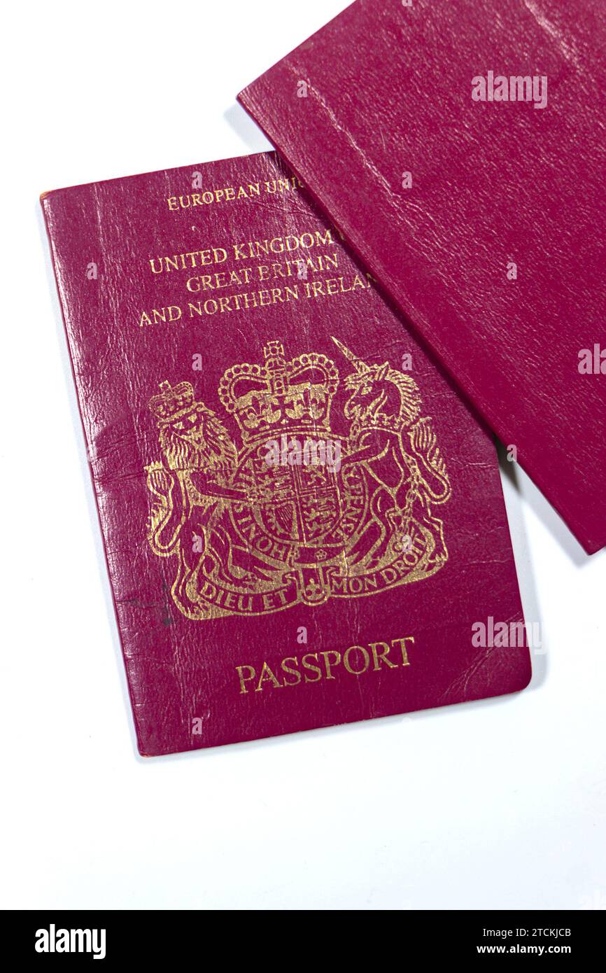 covers of two old maroon UK EU passports isolated on white studio background Stock Photo