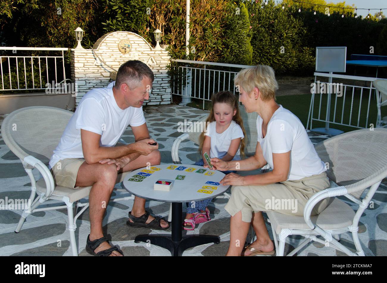 family with one child playing uno. Stock Photo