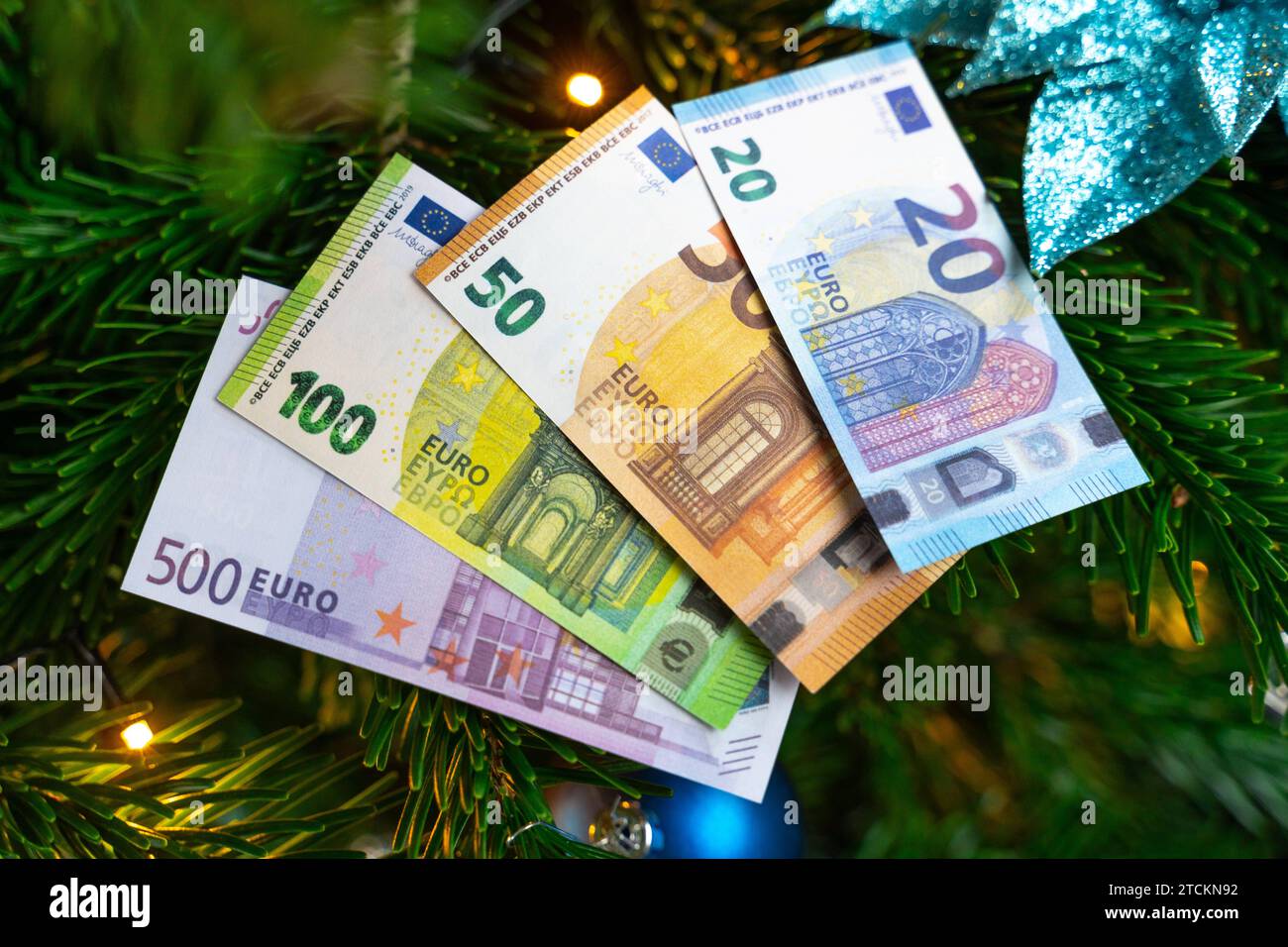 Augsburg, Bavaria, Germany - December 13, 2023: Euro cash banknotes on a decorated Christmas tree. Costs and gift concept *** Euro Bargeld Geldscheine auf einem geschmückten Weihnachtsbaum. Kosten und Geschenk Konzept Stock Photo