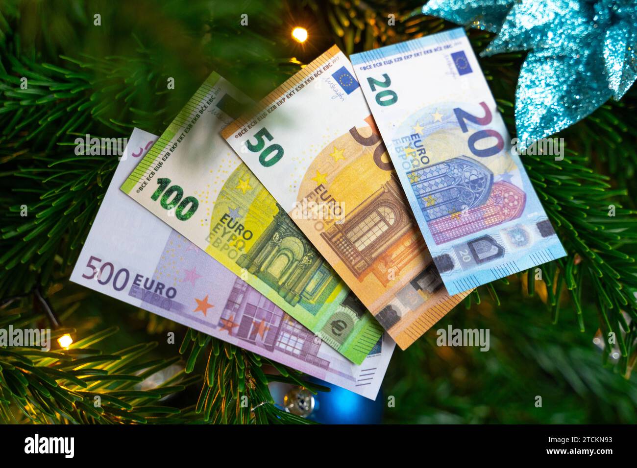 Augsburg, Bavaria, Germany - December 13, 2023: Euro cash banknotes on a decorated Christmas tree. Costs and gift concept *** Euro Bargeld Geldscheine auf einem geschmückten Weihnachtsbaum. Kosten und Geschenk Konzept Stock Photo