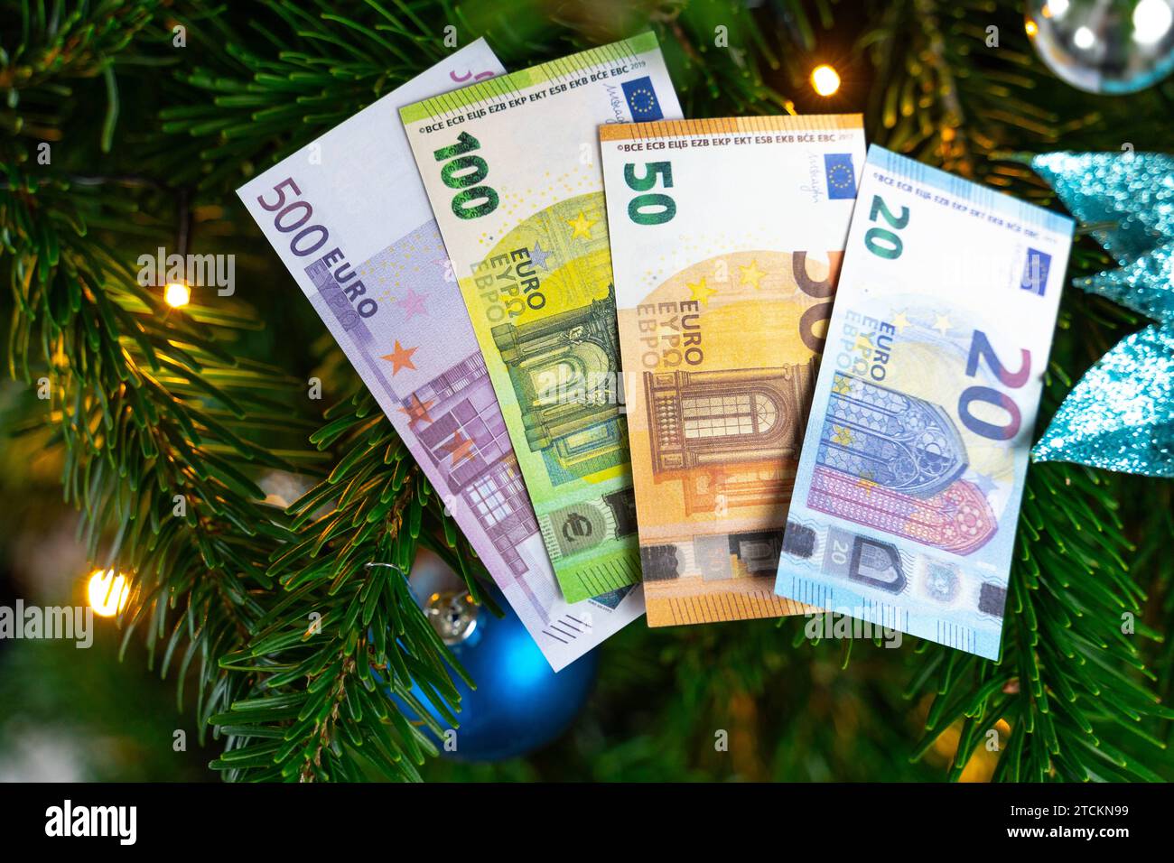 Augsburg, Bavaria, Germany - December 13, 2023: Euro cash banknotes on a decorated Christmas tree. Costs and gift concept *** Euro Bargeld Geldscheine auf einem geschmückten Weihnachtsbaum. Kosten und Geschenk Konzept Stock Photo