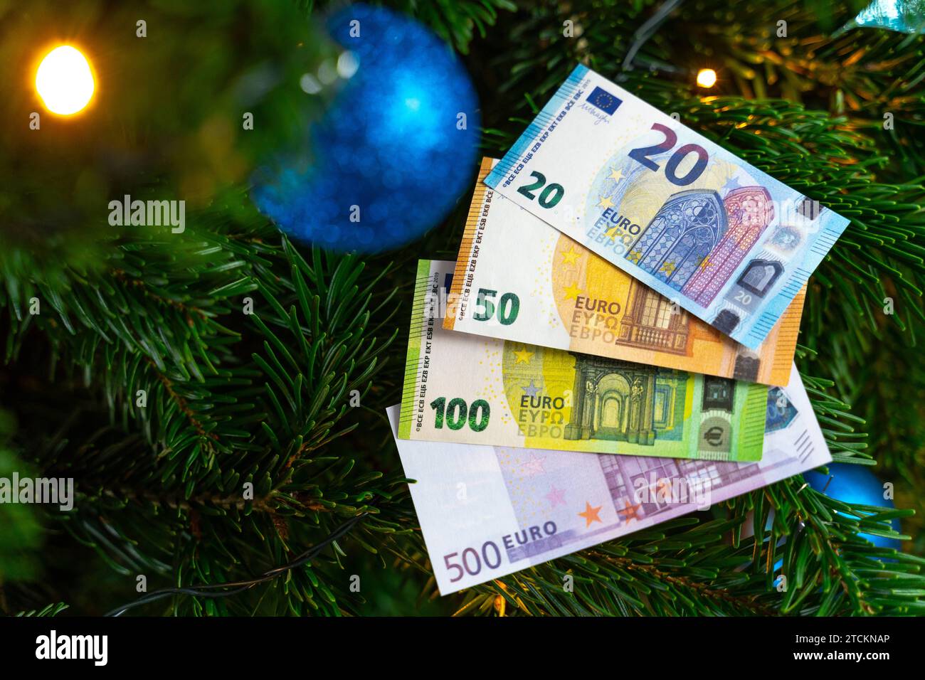 Augsburg, Bavaria, Germany - December 13, 2023: Euro cash banknotes on a decorated Christmas tree. Costs and gift concept *** Euro Bargeld Geldscheine auf einem geschmückten Weihnachtsbaum. Kosten und Geschenk Konzept Stock Photo