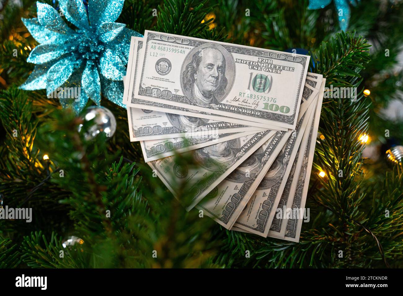 Augsburg, Bavaria, Germany - December 13, 2023: US Dollar cash banknotes in a decorated Christmas tree. Tradition and cost concept *** US Dollar Bargeld Geldscheine in einem geschmückten Weihnachtsbaum. Tradition und Kosten Konzept Stock Photo