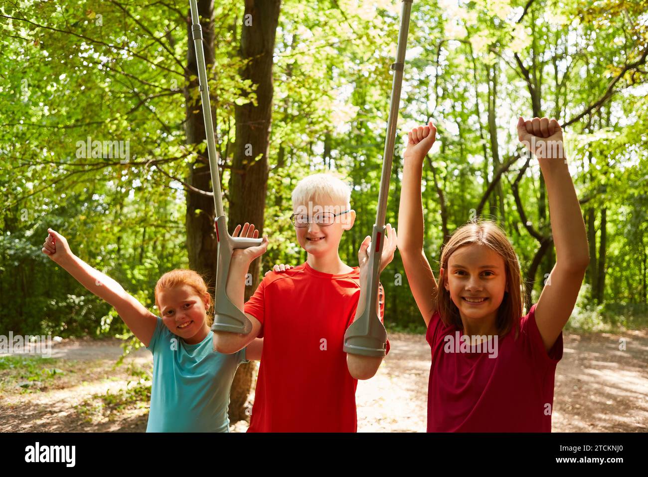 Portrait of happy female friends with disabled boy holding crutches at forest Stock Photo