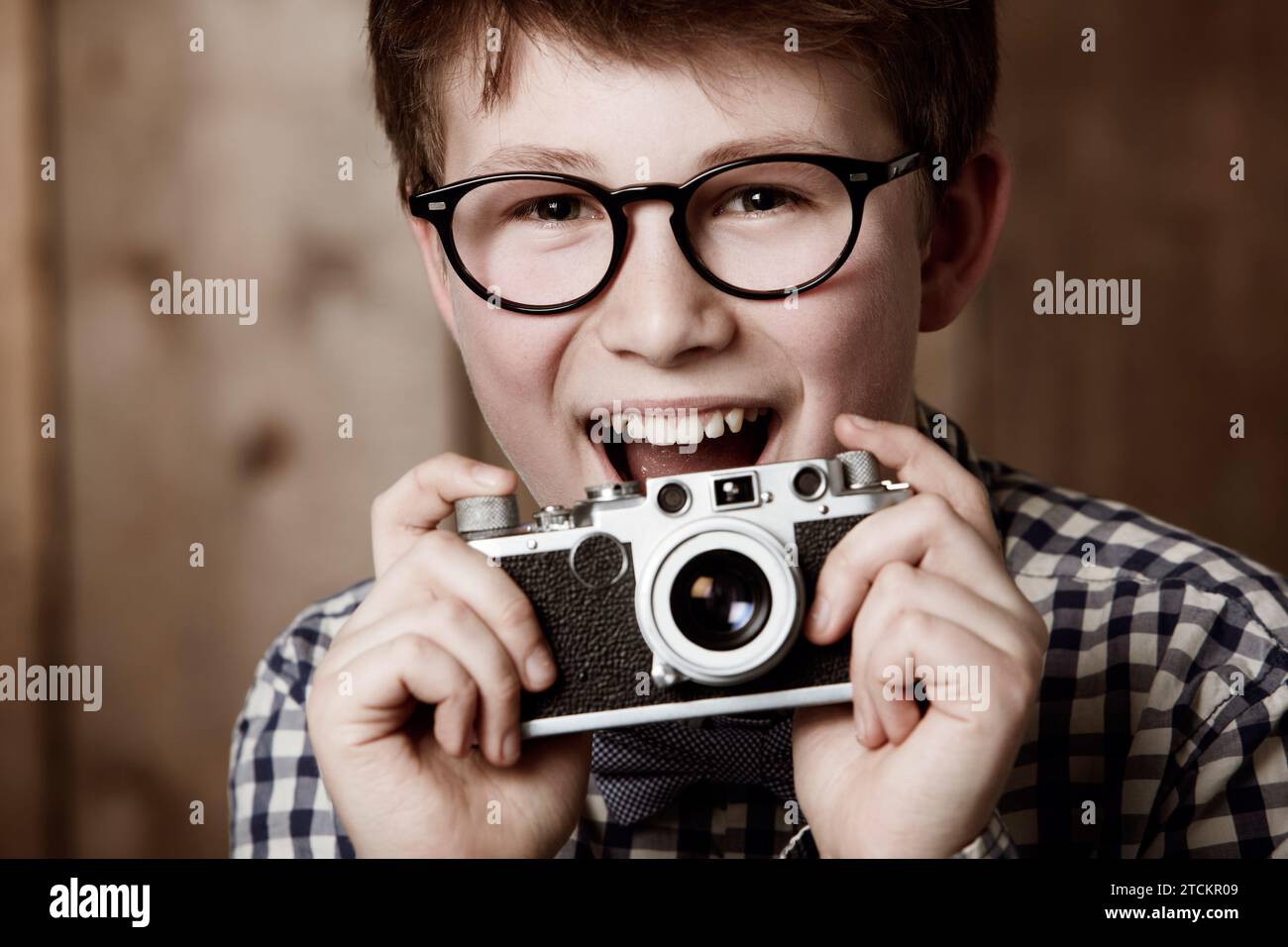 Mockup, portrait and boy with vintage camera with happiness and edgy fashion in glasses by backdrop. Child, face and nerd with retro photography Stock Photo