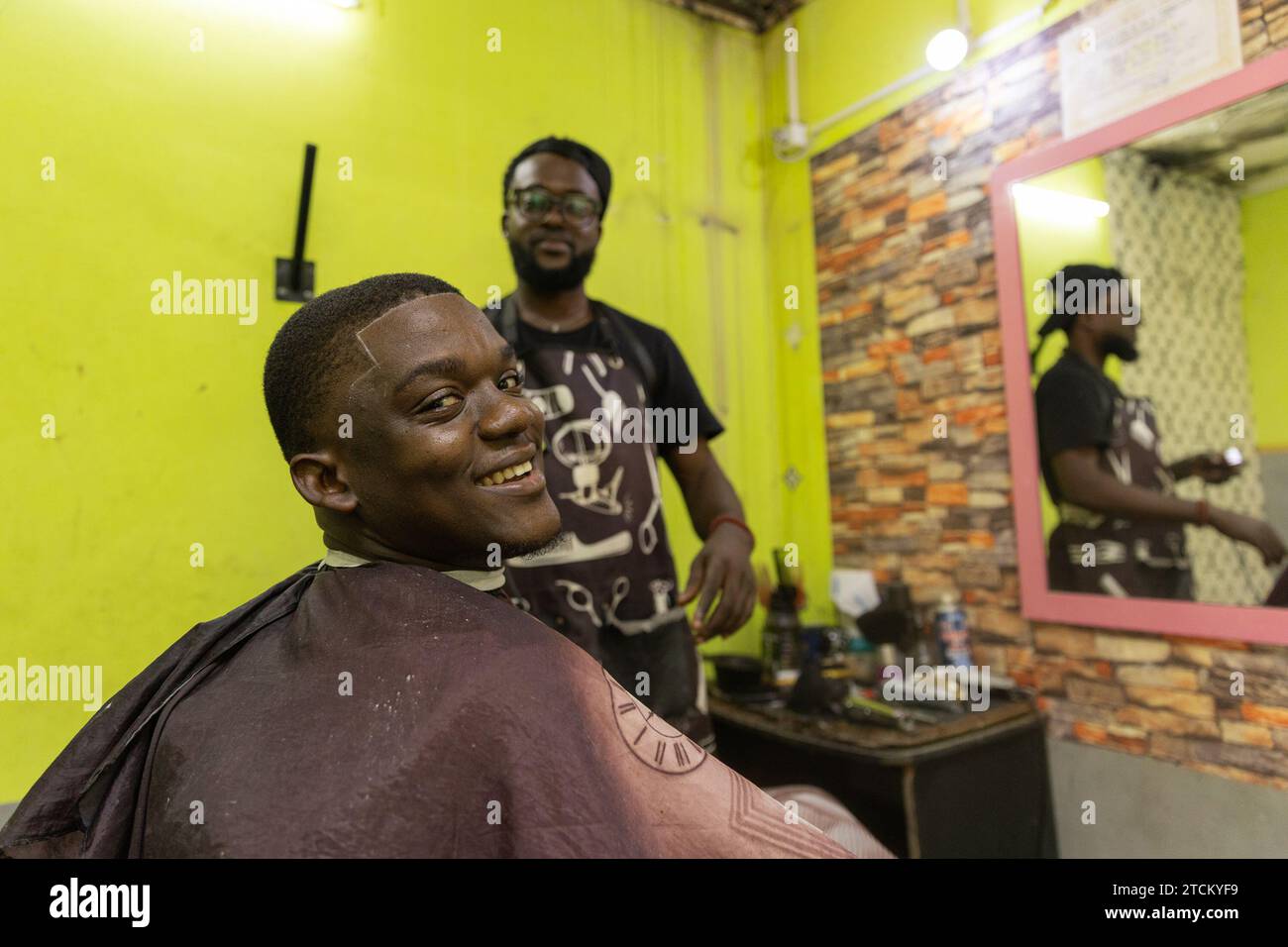 A smiling boy at the getting his hair cut in Africa Stock
