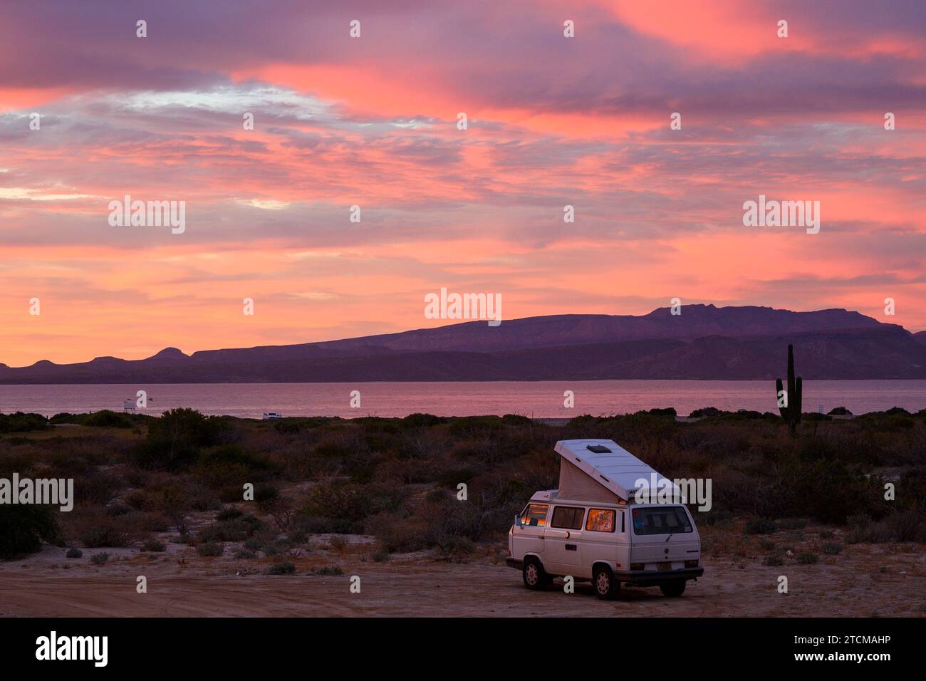 sunset and VW Westfalia camped at , Playa Tecolote, Baja California Sur, Mexico. Stock Photo