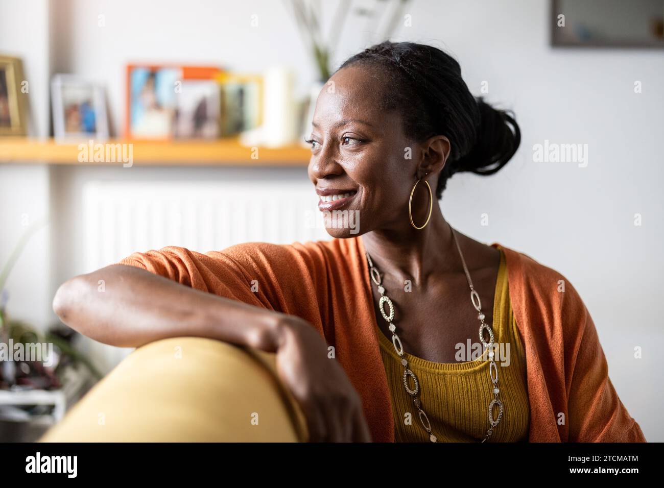 Portrait of smiling woman relaxing on sofa at home Stock Photo - Alamy