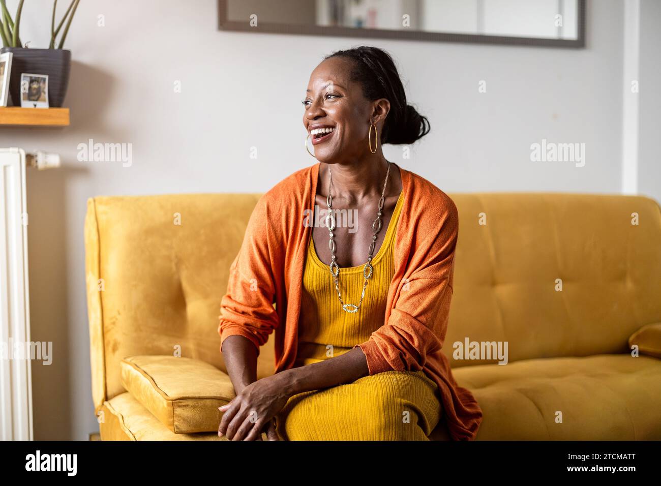 Portrait of smiling woman relaxing on sofa at home Stock Photo - Alamy