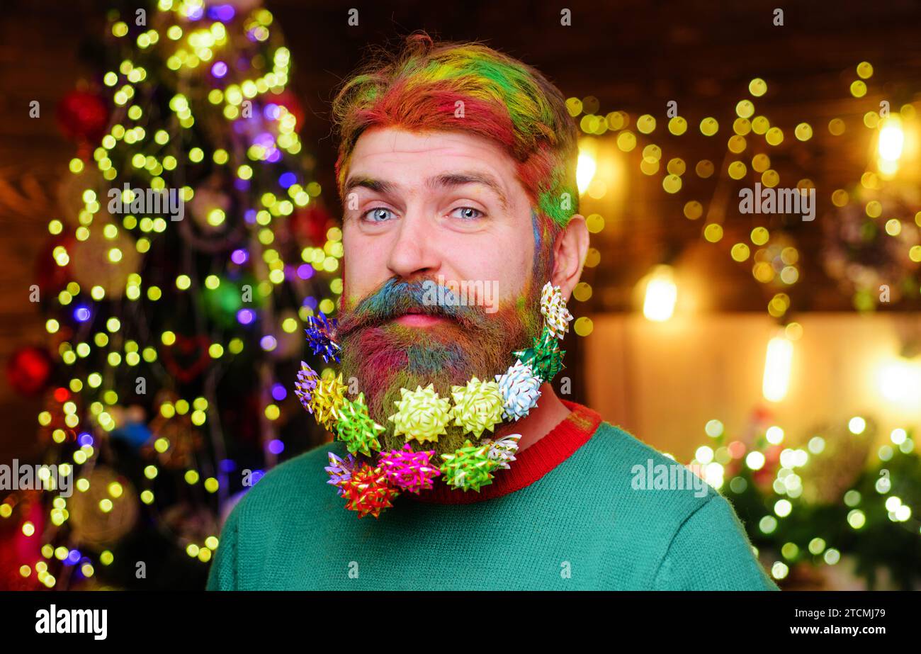 Merry Christmas, Happy New year. Smiling man with decorated beard for New Year or Christmas holidays. Closeup portrait of bearded man with Christmas Stock Photo
