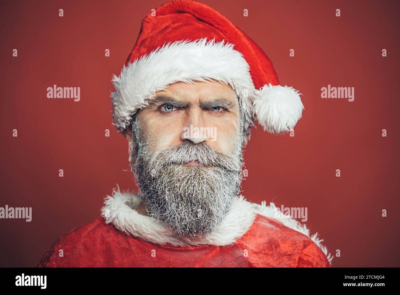 Christmastime. Winter holiday celebration. Merry Christmas and Happy New Year. Closeup portrait of Santa Claus with snowy beard. Serious bearded man Stock Photo