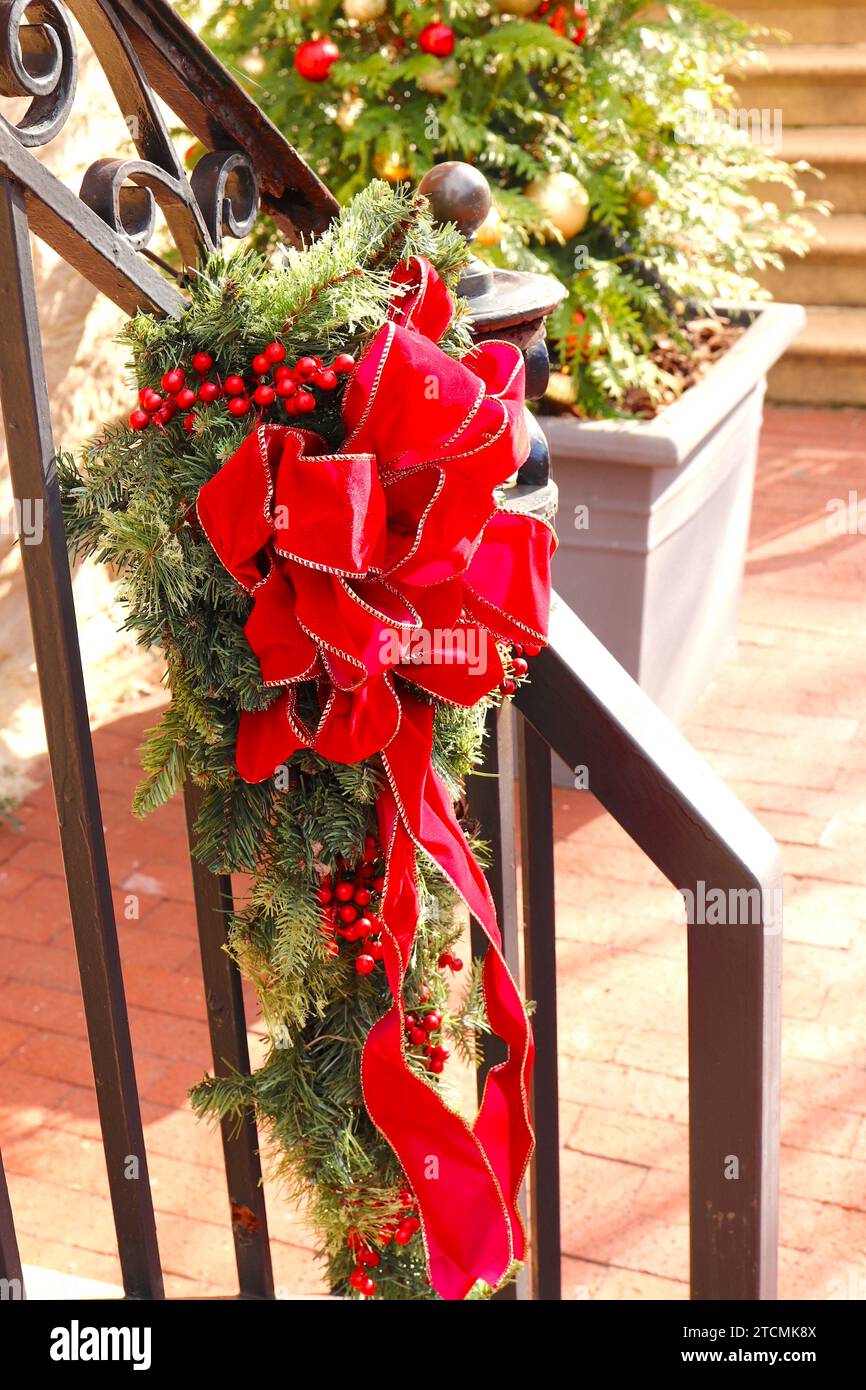 Christmas Bough Tied with Red Ribbon on Outdoor Staircase Railing Stock Photo