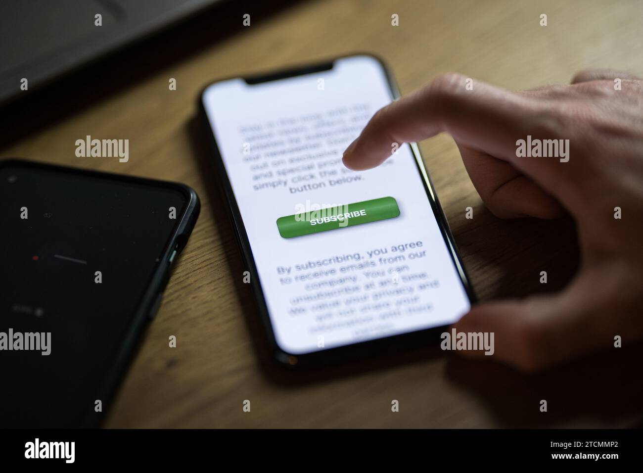 Clicking on green subscribe button on smartphone app Stock Photo - Alamy