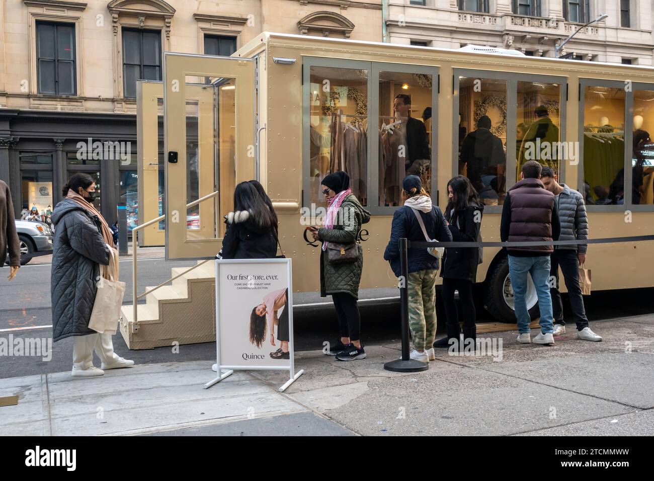 People line up to enter the San Francisco based online direct to consumer company Quince brand activation vehicle, in the Flatiron neighborhood of New York on Saturday, December 9, 2023. Quince is primarily an online merchant selling clothing, home goods and accessories.  (© Richard B. Levine) Stock Photo