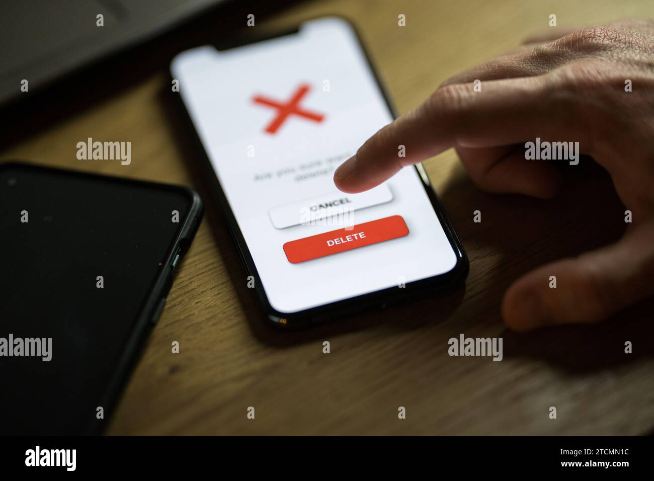 Clicking on red delete button on smartphone app Stock Photo