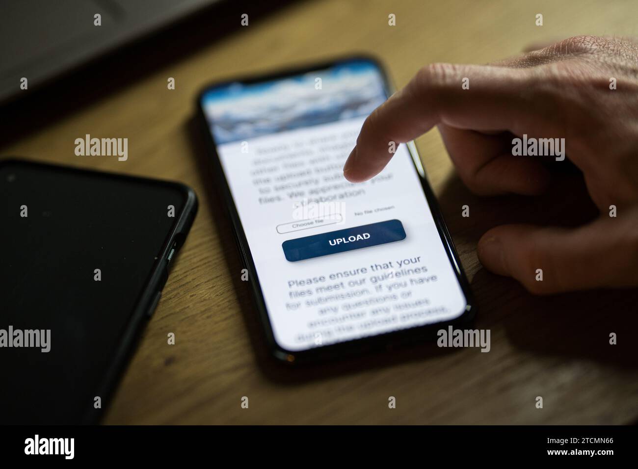Clicking on upload button on smartphone app Stock Photo