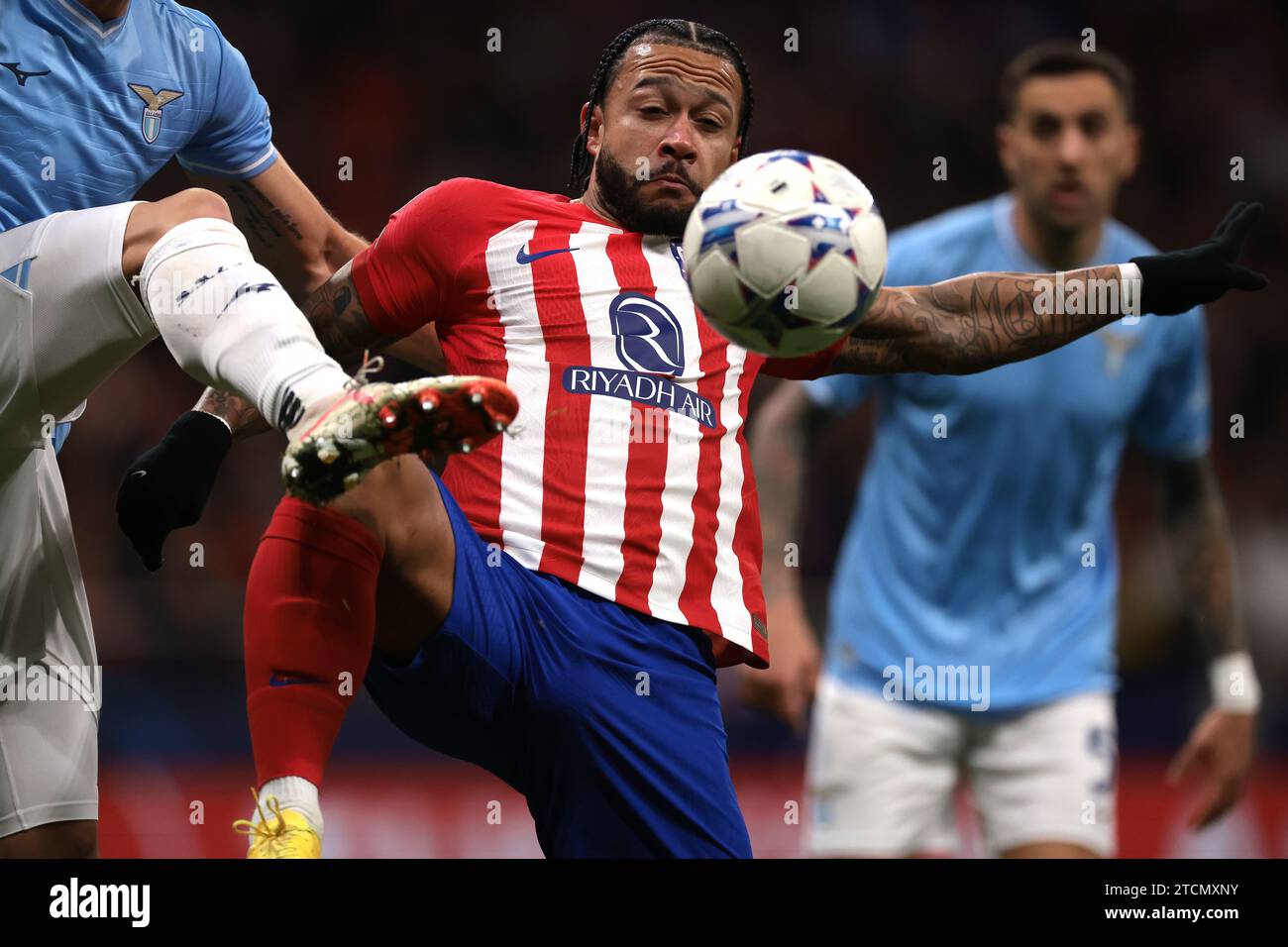 Madrid, Spain. 13th Dec, 2023. Memphis Depay of Atletico Madrid is challenged by a high boot from an SS Lazio opponent during the UEFA Champions League match at Civitas Metropolitan Stadium, Madrid. Picture credit should read: Jonathan Moscrop/Sportimage Credit: Sportimage Ltd/Alamy Live News Stock Photo