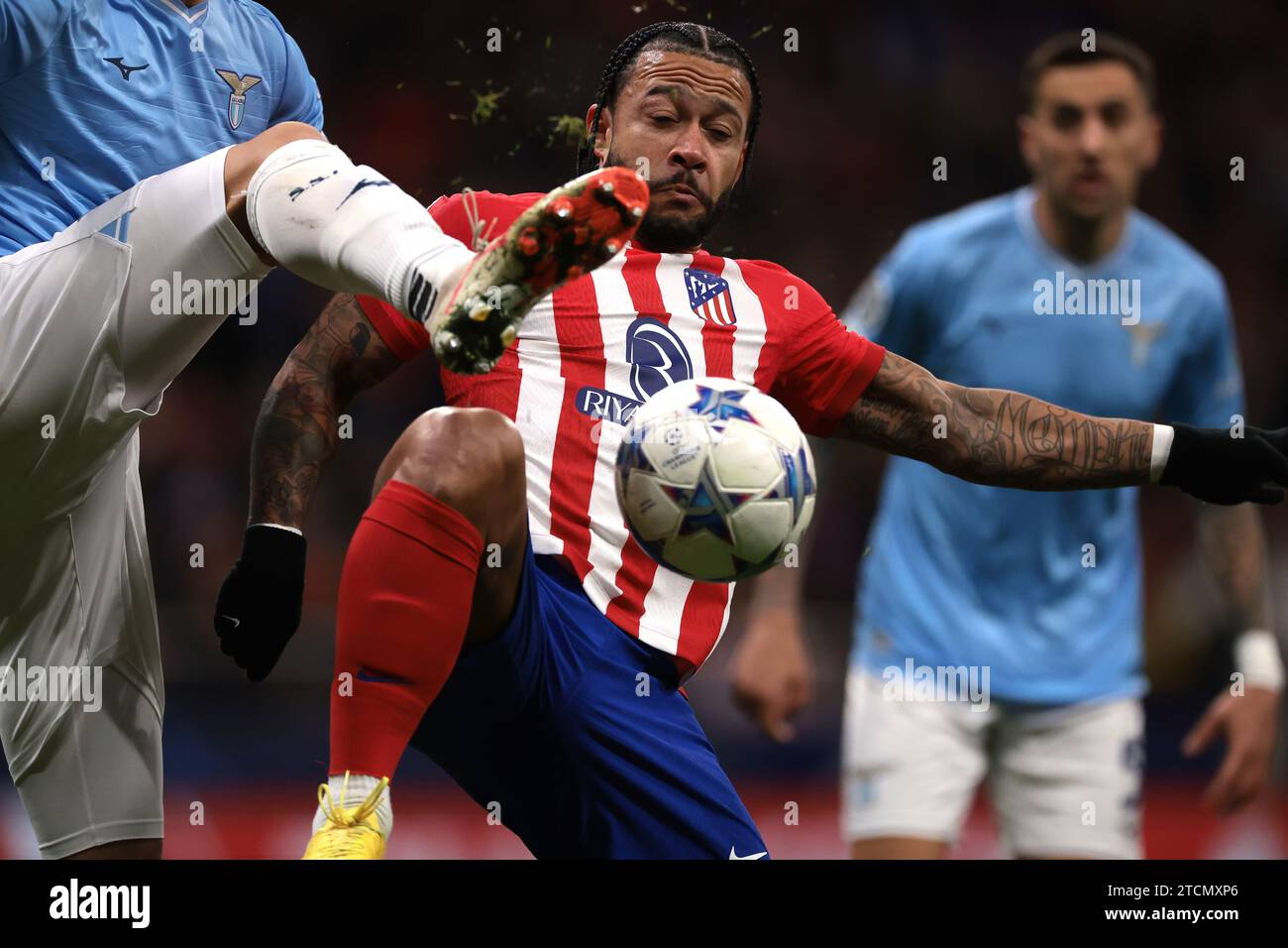 Madrid, Spain. 13th Dec, 2023. Memphis Depay of Atletico Madrid is challenged by a high boot from an SS Lazio opponent during the UEFA Champions League match at Civitas Metropolitan Stadium, Madrid. Picture credit should read: Jonathan Moscrop/Sportimage Credit: Sportimage Ltd/Alamy Live News Stock Photo