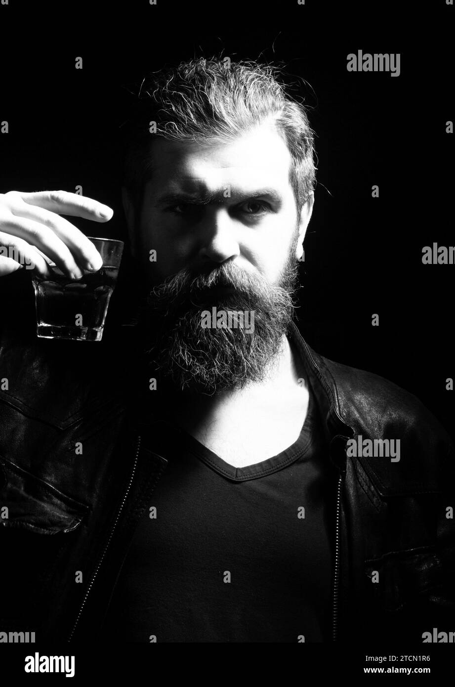 Man drinking whiskey, brandy, cognac. Man with glass of brandy. Bearded