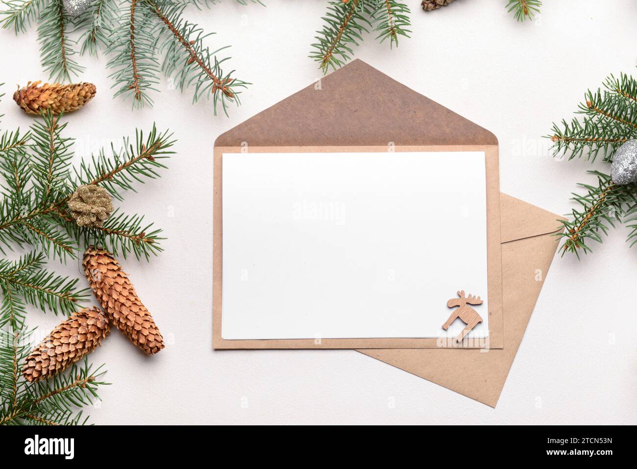 Blank paper with envelopes, fir branches and pine cones on white ...