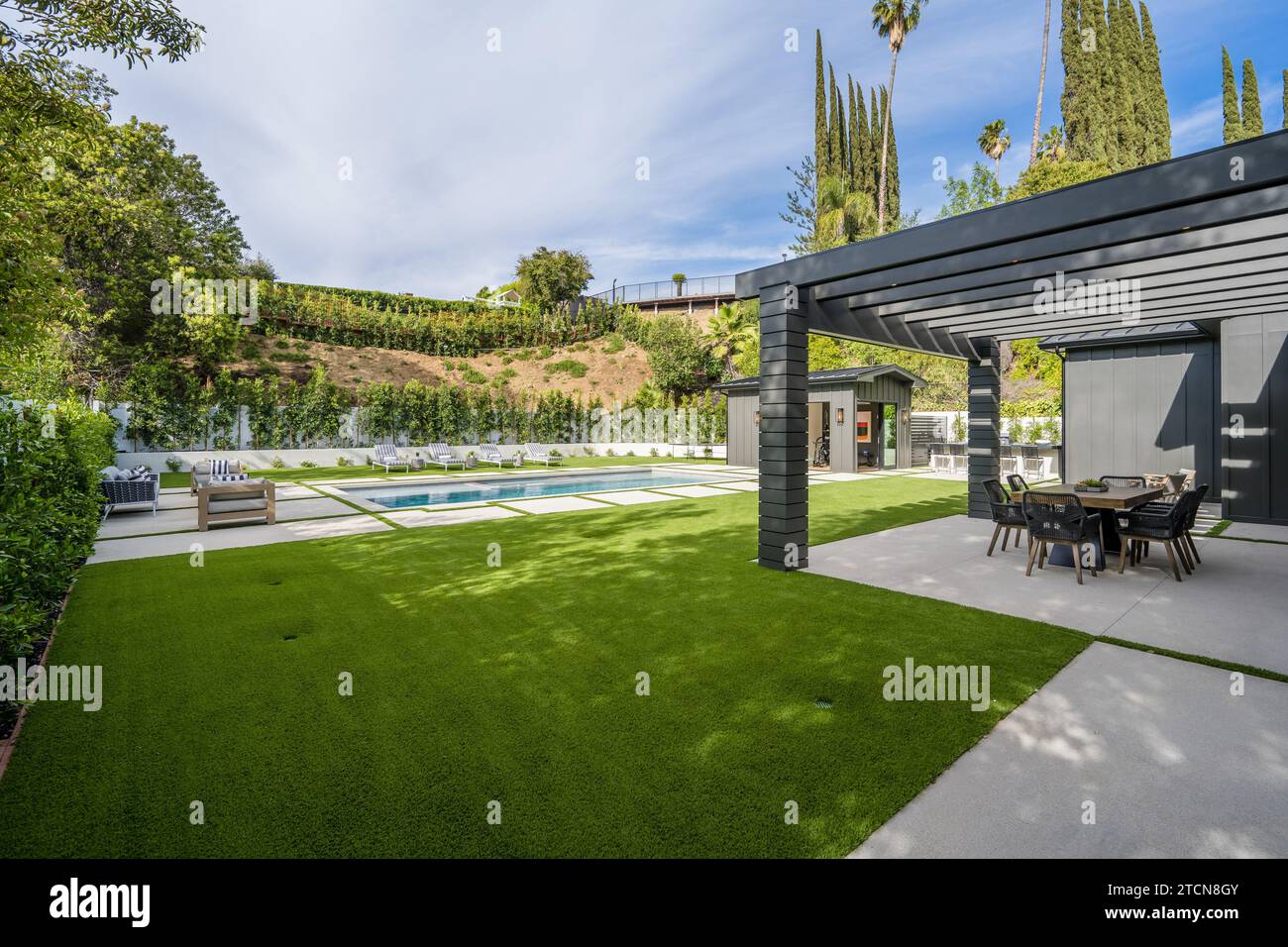 This image shows an outdoor patio overlooking a stunning swimming pool