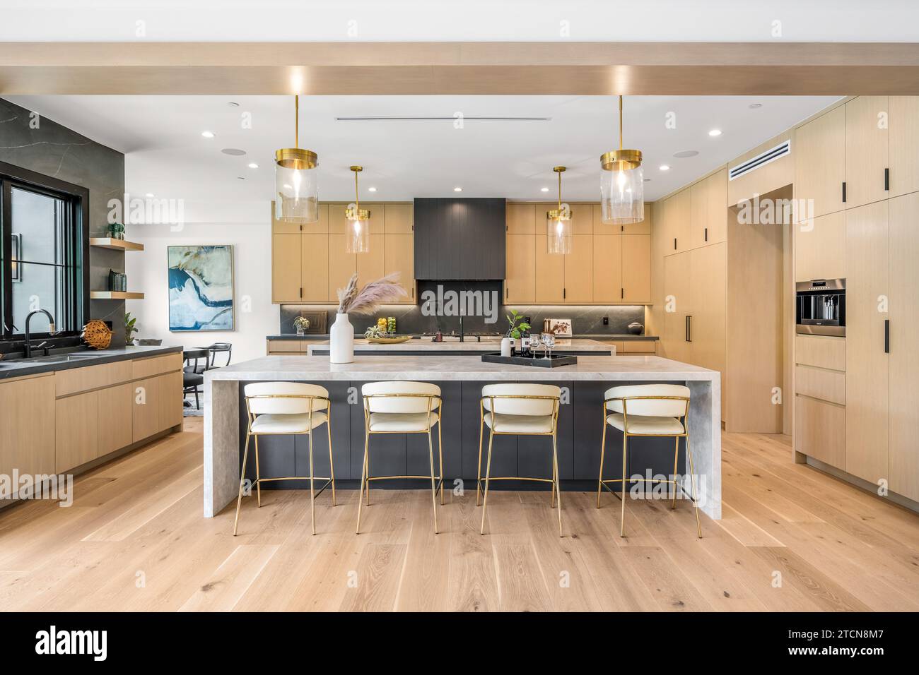 This modern kitchen features two breakfast tables and stools in a