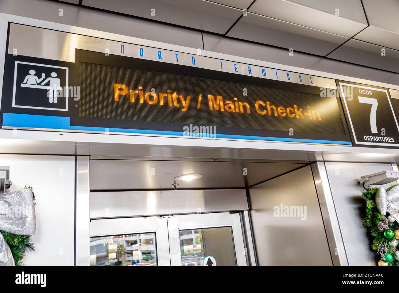 Miami Florida,Miami International Airport MIA,inside interior indoors,terminal entrance priority main check-in,digital marquee sign information,employ Stock Photo