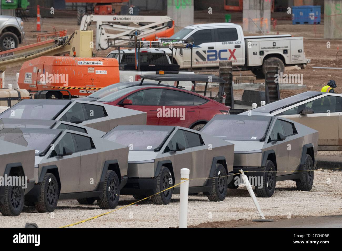 Austin, Texas, USA. 13 December, 2023. New Tesla Cybertrucks are parked outside the huge Tesla factory in southeast Austin as workers make equipment checks and drive them away on December 13, 2023, two weeks after delivering the first models to VIP buyers in a private ceremony. A massive expansion is underway at the Texas Tesla factory with construction on several new buildings underway. Credit: Bob Daemmrich/Alamy Live News Stock Photo