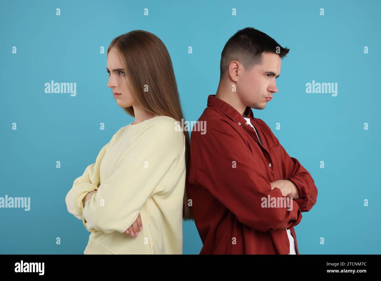 Portrait of resentful couple with crossed arms on light blue background Stock Photo