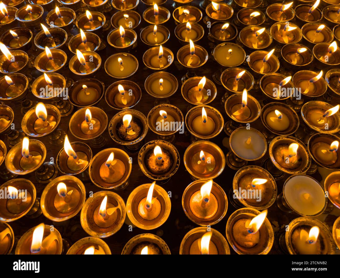 Puja candles are lit at Lo Gekar Monastery in Ghar village is the oldest Buddhist gompa in Nepal, built by Guru Rimpoche in the 8th century - Mustang Stock Photo
