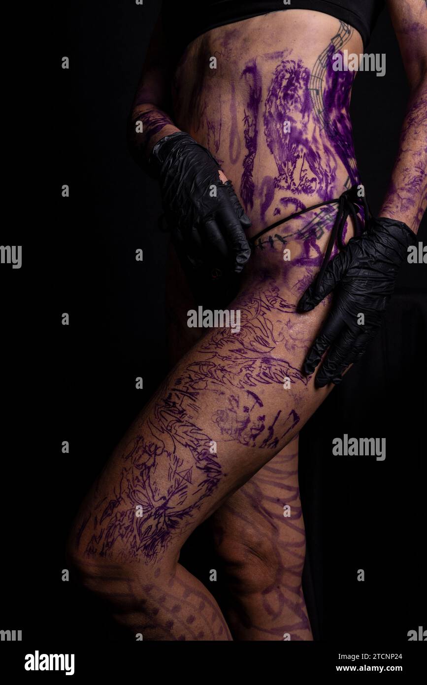 Part of woman's body painted and tattooed against black background Stock Photo