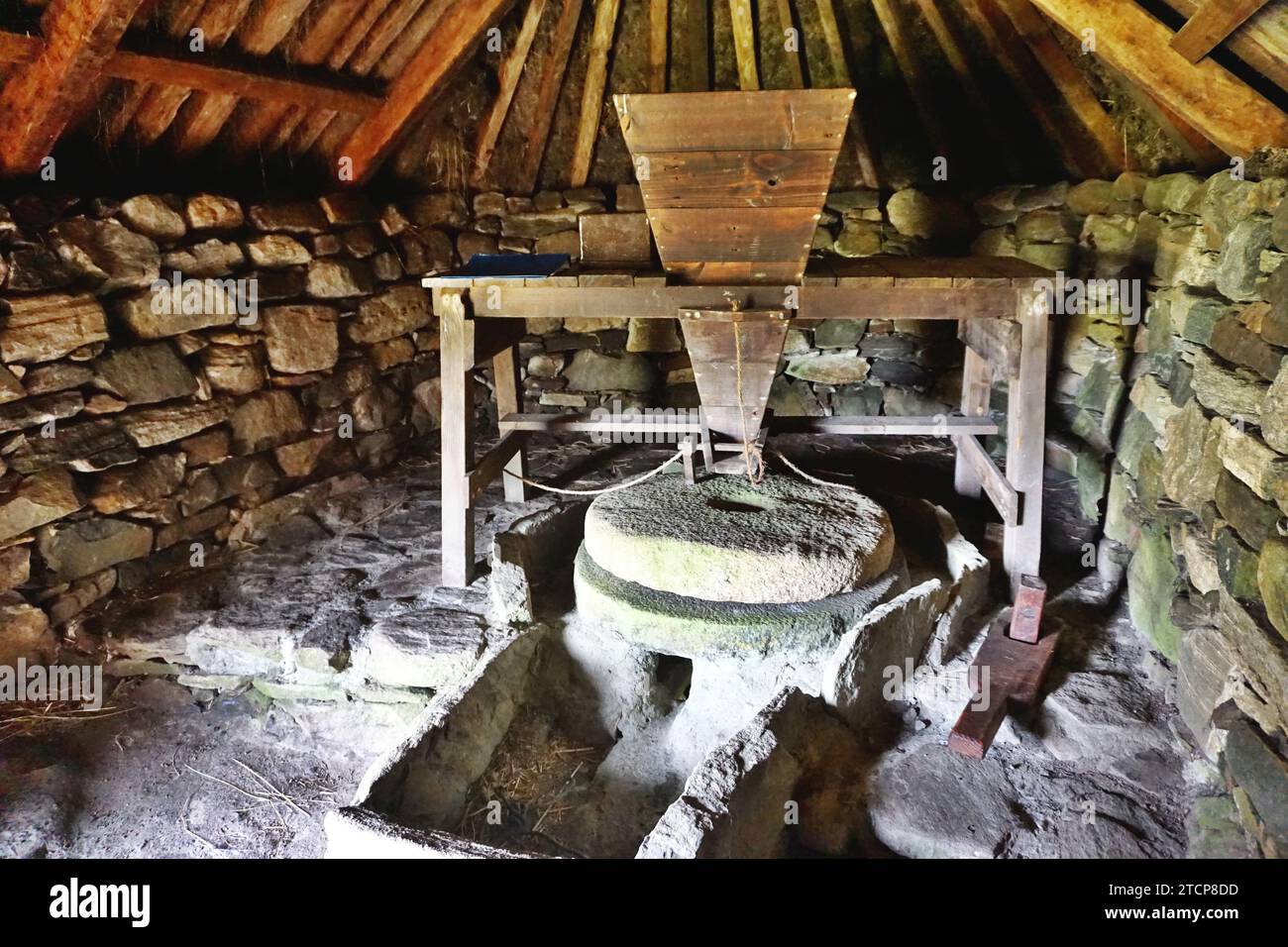Interior of the historic Norse mill on Lewis Island, Scotland. A nearby stream powers a waterwheel that turns the grindstones to grind corn into meal. Stock Photo