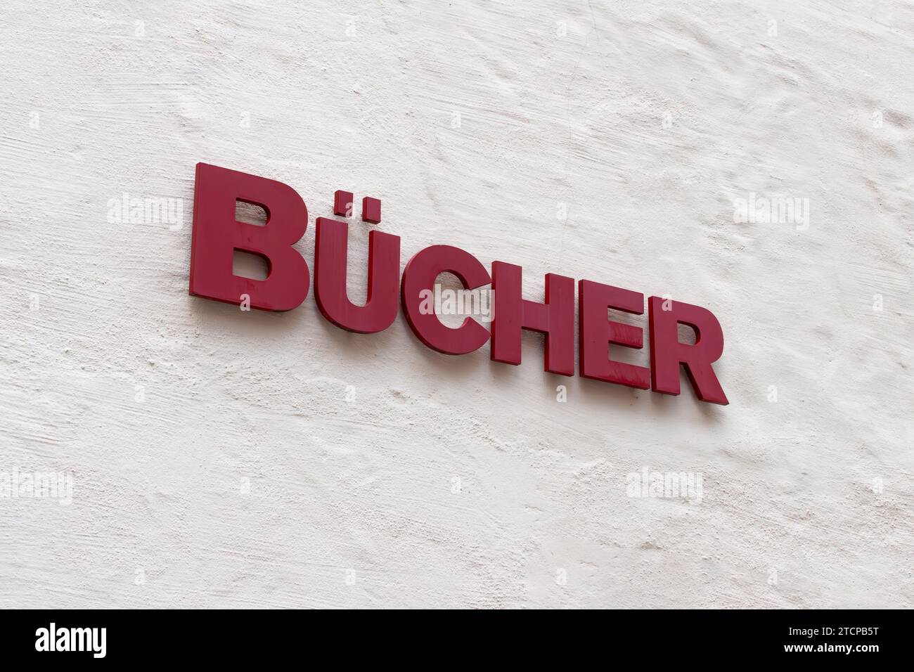 Bücher (books) sign on a building wall. Advertisement symbol of a book store in a city in Germany. Retailer for literature or a library house exterior Stock Photo
