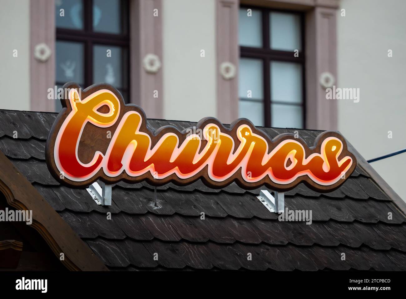 Churros sign of the Spanish cuisine food on a Christmas market. The fried dough is sold in Germany at events and festivals. The street food is popular Stock Photo