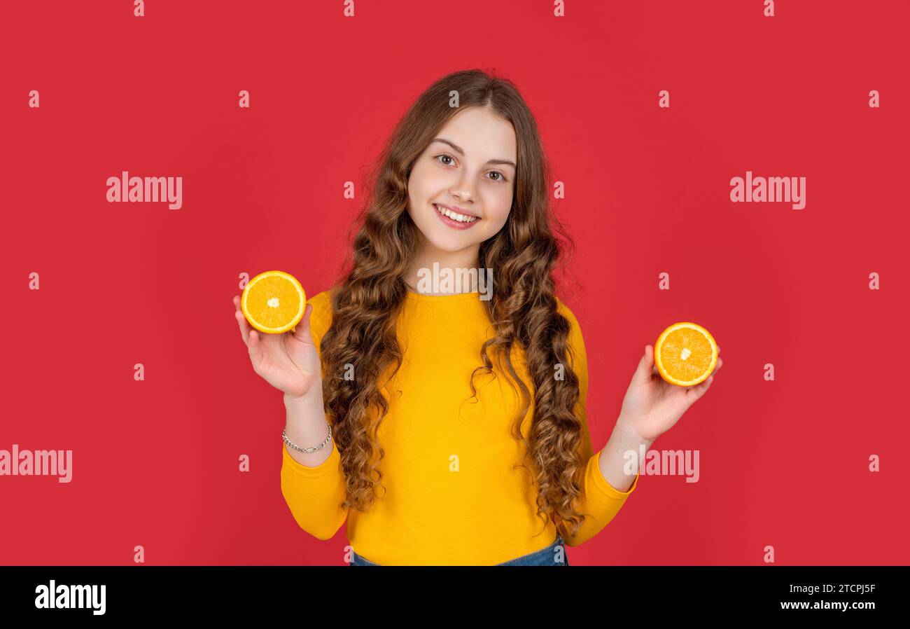 happy teen girl hold orange fruit on purple background Stock Photo - Alamy