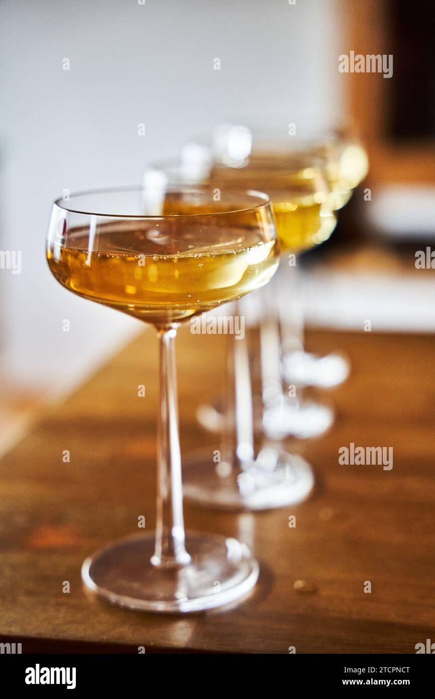 A closeup of glasses with vibrant yellow liquid standing side-by-side. Stock Photo