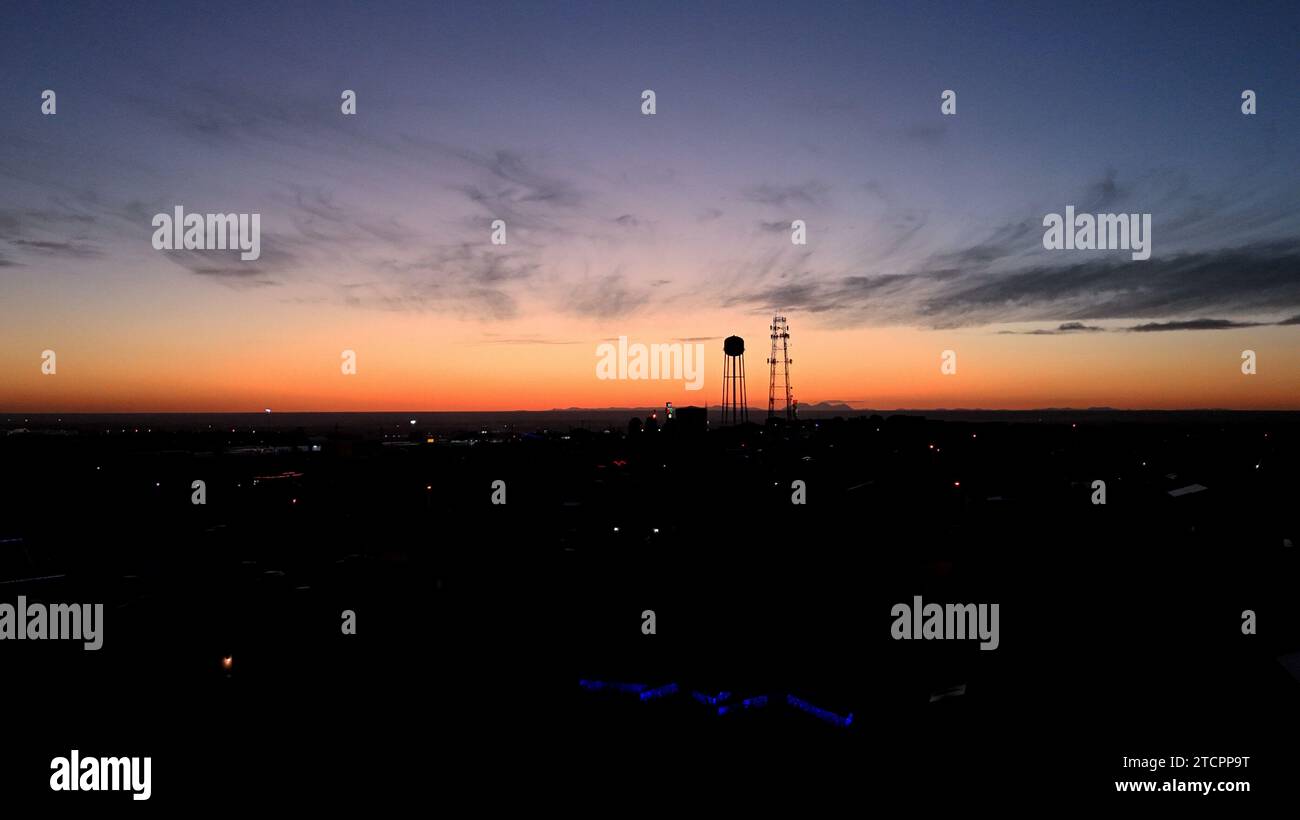 An aerial view of a city skyline illuminated by a stunning orange and ...